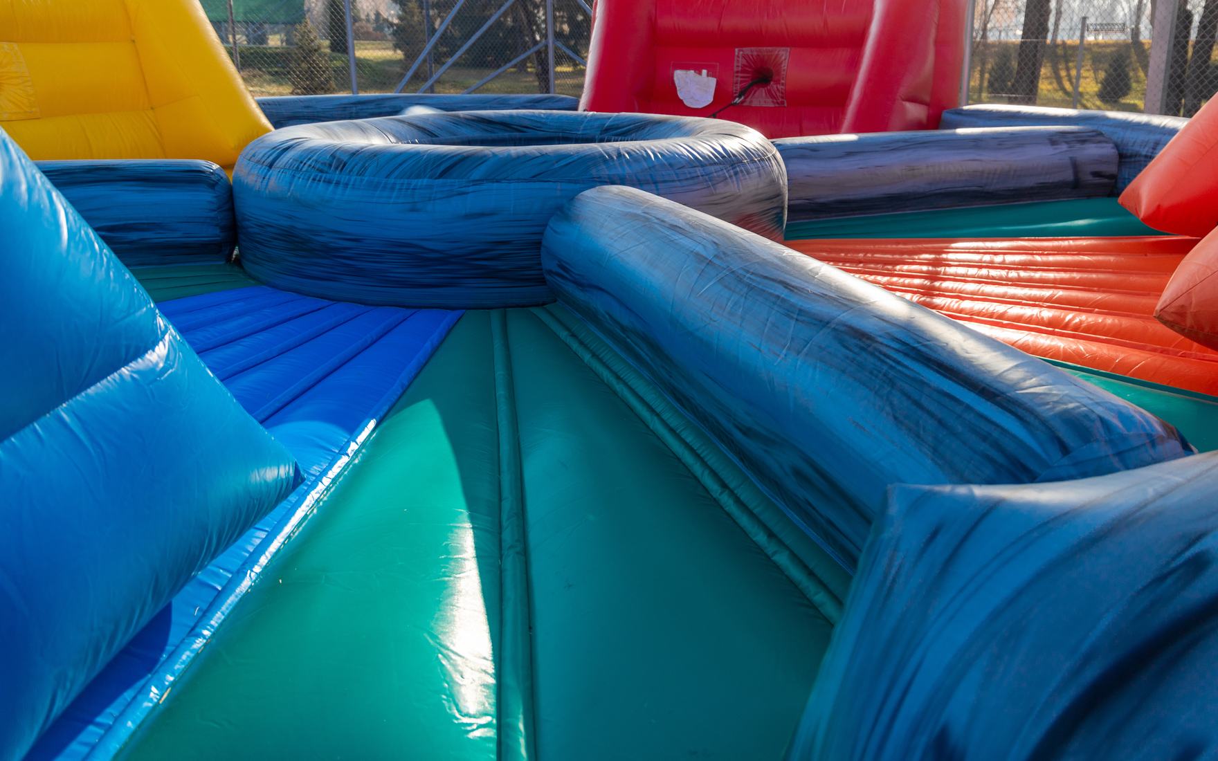 Blue and teal inflatable obstacle maze seen from ground level