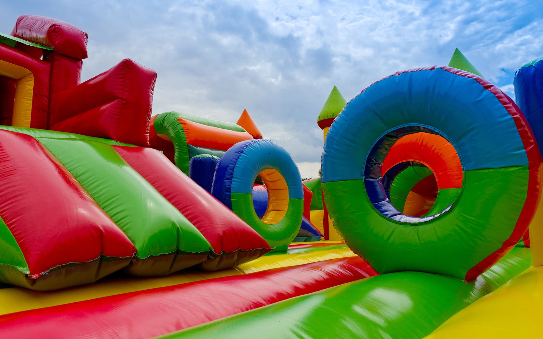 Red and green obstacle course with tunnel rings under a blue sky