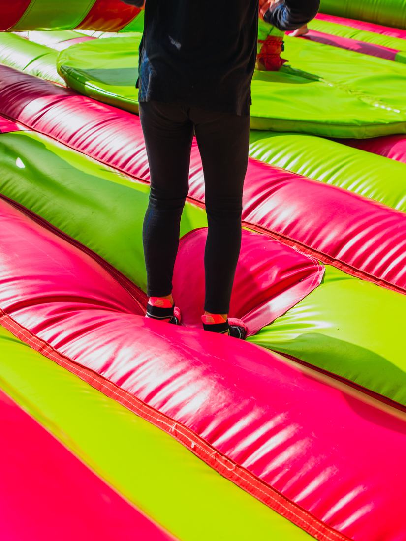 Guest walking across a pink and lime obstacle course